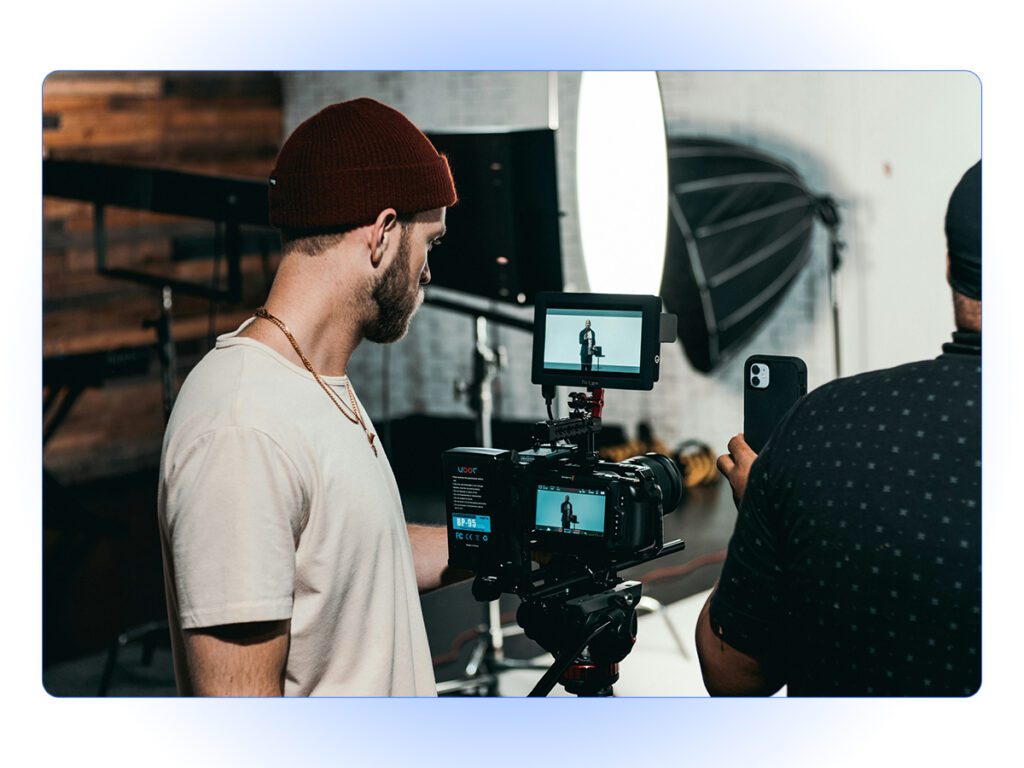 A stock photo of a man filming a video.